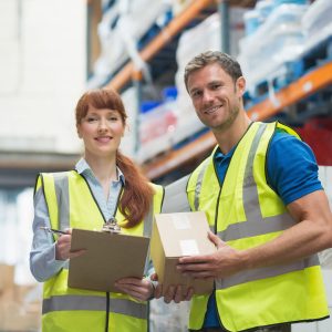 Smiling warehouse manager and delivery man in warehouse